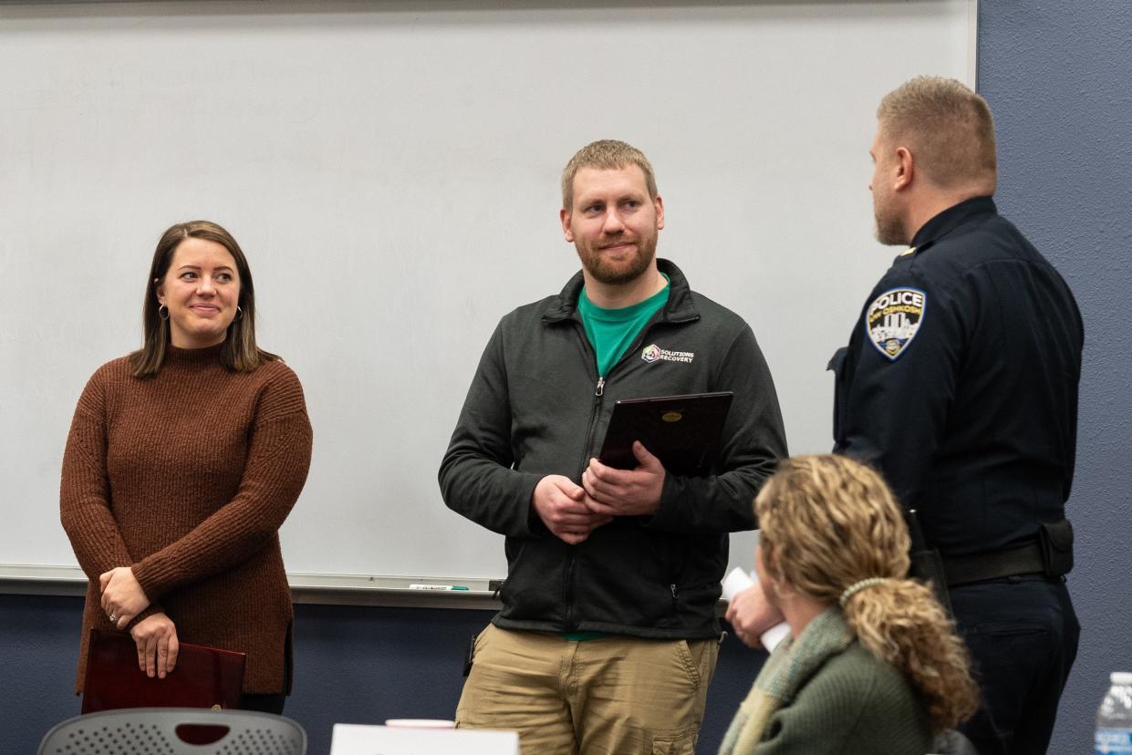 Megan Edwards and Trevor Fenrich of Solutions Recovery listen to University of Wisconsin-Oshkosh Chief of Police Chris Tarmann.