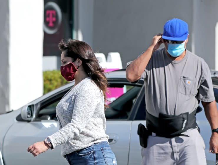 People wear their face masks while outside the 1800 block of Newport Blvd., in Costa Mesa on Saturday, Nov. 14, 2020.