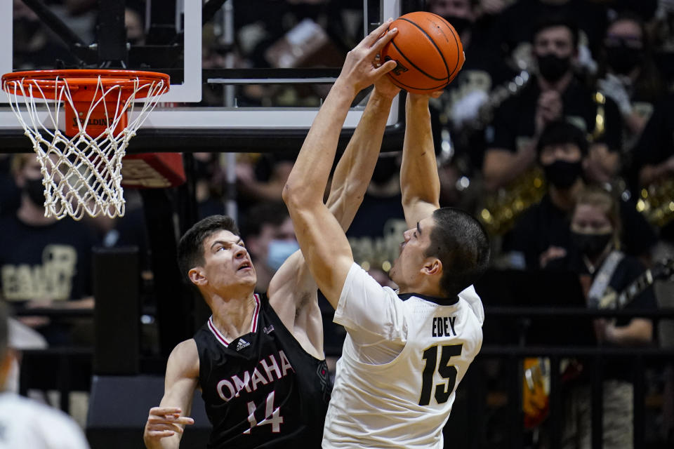 Omaha's Dylan Brougham (14) block's the shot of Purdue's Zach Edey (15) during the first half of an NCAA college basketball game in West Lafayette, Ind., Friday, Nov. 26, 2021. (AP Photo/Michael Conroy)