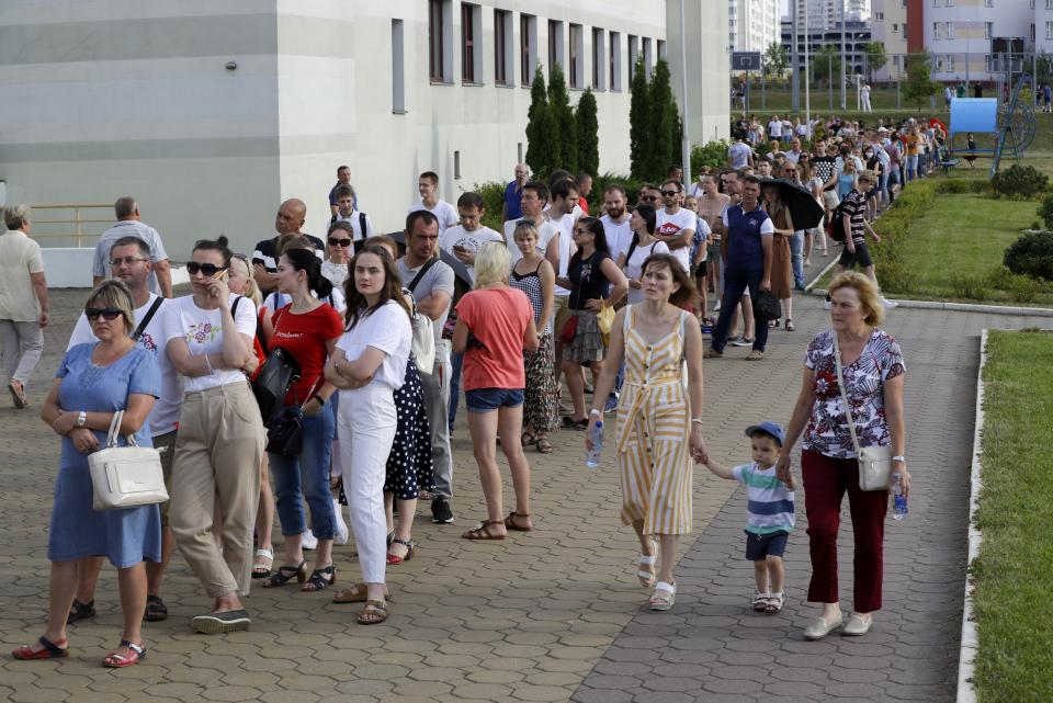 People queue to cast their votes in the Belarusian presidential election in Minsk, Belarus, Sunday, Aug. 9, 2020. Belarusians are voting on whether to grant incumbent president Alexander Lukashenko a sixth term in office, extending his 26-years rule, following a campaign marked by unusually strong demonstrations by opposition supporters. (AP Photo/Sergei Grits)