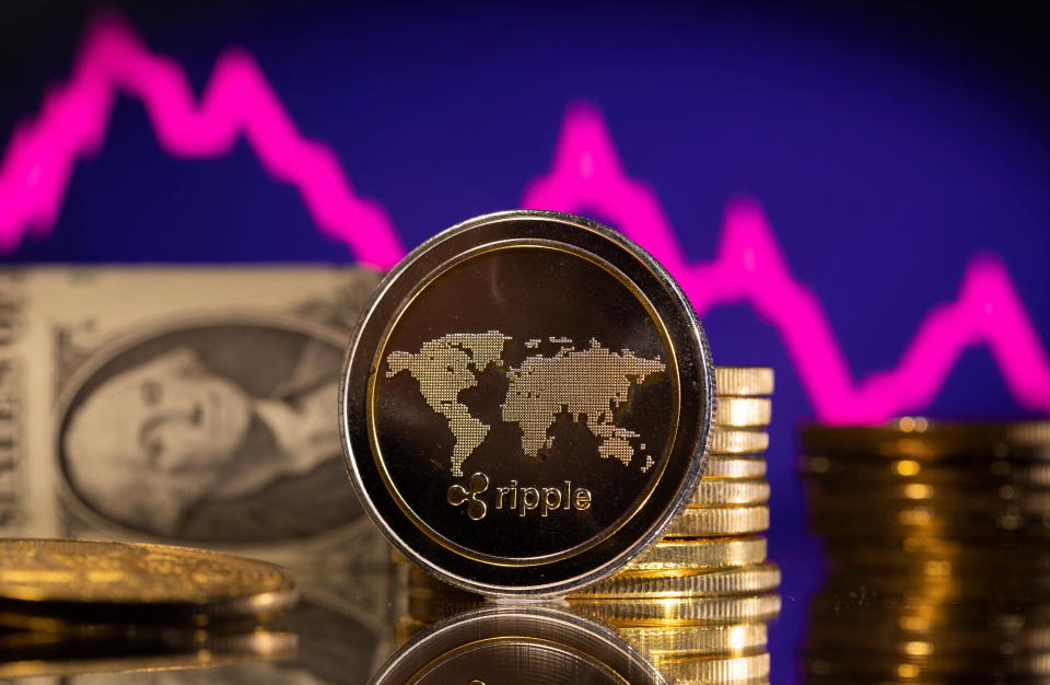 A representations of cryptocurrency Ripple is seen in front of a stock graph and U.S. dollar in this illustration taken, January 24, 2022. REUTERS/Dado Ruvic/Illustration