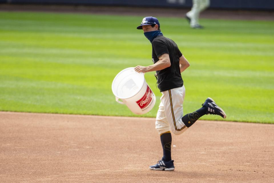 Milwaukee Brewers manager Craig Counsell runs with a bucket after it was announced that the Brewers home opener was postponed after two St. Louis Cardinals employees tested positive for the coronavirus, Friday, July 31, 2020, in Milwaukee. (AP Photo/Morry Gash)