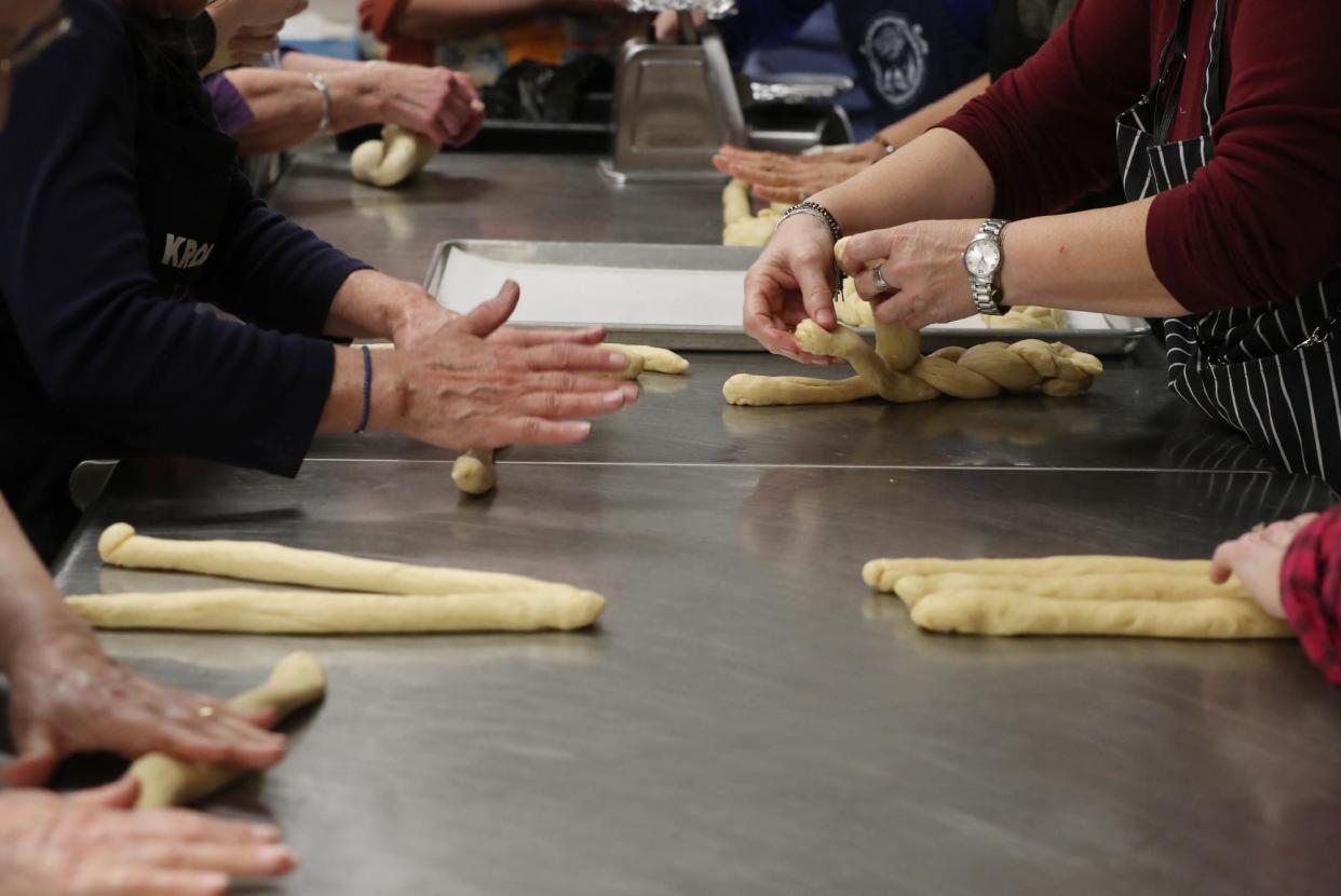 Volunteer bakers from Annunciation's Philoptochos Society and Archangel Michael Kalymnian Society of Campbell, Ohio, roll and braid dough to make tsourekia, braided Easter bread, at Annunciation Greek Orthodox Church in Akron Tuesday.