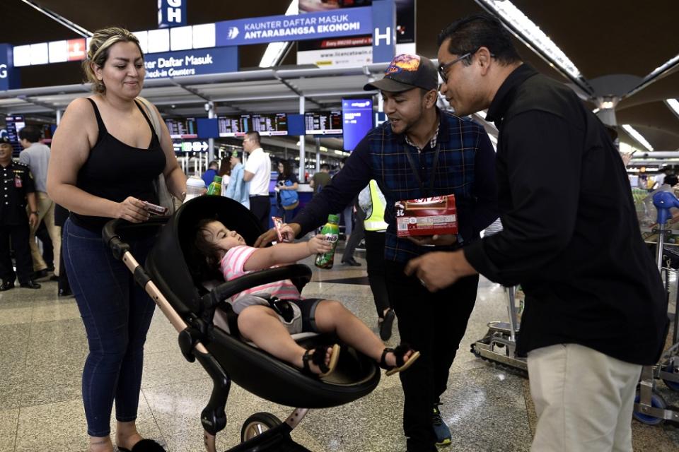 Malaysian Airport personnel distribute refreshments to passengers at the Kuala Lumpur International Airport August 24,2019.