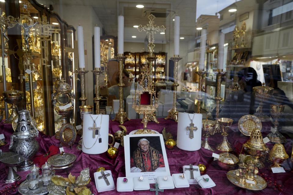 A picture of late Emeritus Pontiff Benedict XVI is displayed of a shop window selling religious items in Rome, Monday, Jan. 2, 2023. Benedict XVI, the German theologian who will be remembered as the first pope in 600 years to resign, has died, the Vatican announced Saturday. He was 95.(AP Photo/Gregorio Borgia)