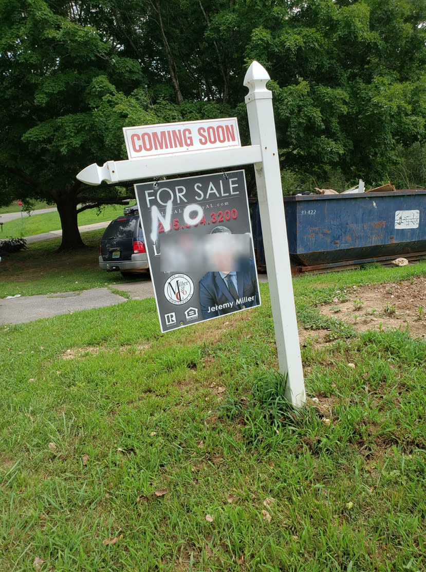 An interracial couple that owns a real estate company found a racist slur painted on one of their signs (Credit: Facebook)