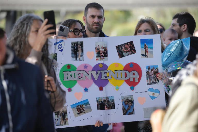 Luisa, junto a sus nietos, esperó en Ezeiza a su hija con un cartel de bienvenida