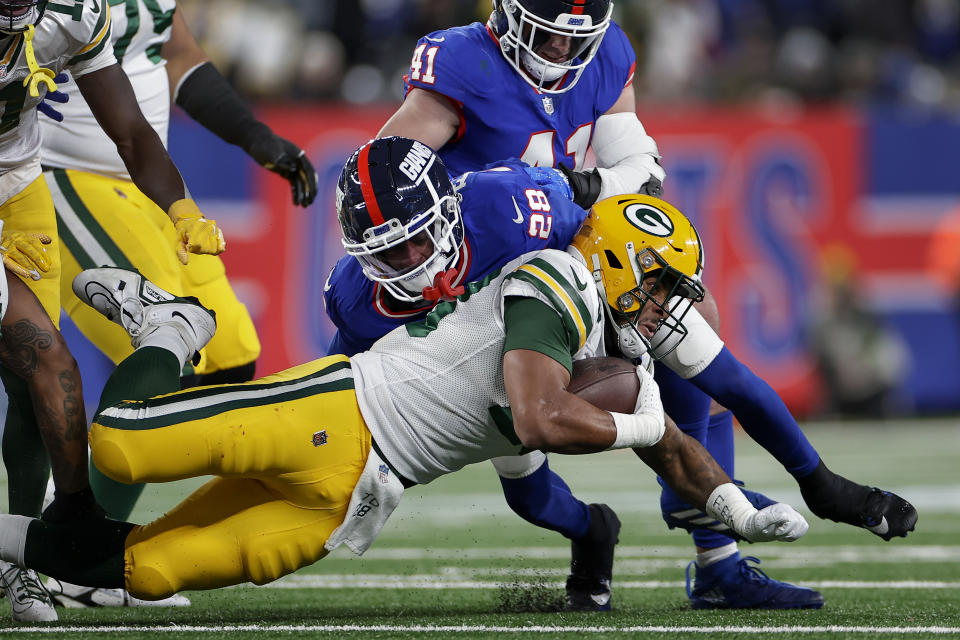 New York Giants cornerback Cor'Dale Flott (28) tackles Green Bay Packers safety Darnell Savage (26) during the second quarter of an NFL football game, Monday, Dec. 11, 2023, in East Rutherford, N.J. (AP Photo/Adam Hunger)