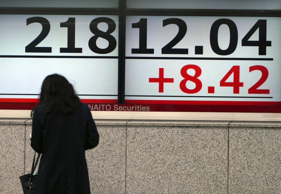 A woman looks at an electronic stock board showing Japan's Nikkei 225 index at a securities firm in Tokyo Friday, Nov. 16, 2018. Shares were mixed in early trading in Asia on Friday on revived concerns over the prospects for a breakthrough in trade tensions between the U.S. and China.(AP Photo/Eugene Hoshiko)