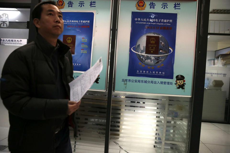 A Chinese man walks past billboards announcing a new Chinese passport issued in May this year at a passport office in Beijing, China, Friday, Nov. 23, 2012. The Philippines has protested China's depiction of its claims over the entire South China Sea in an image of a map printed on newly issued Chinese e-passports. (AP Photo/Ng Han Guan)