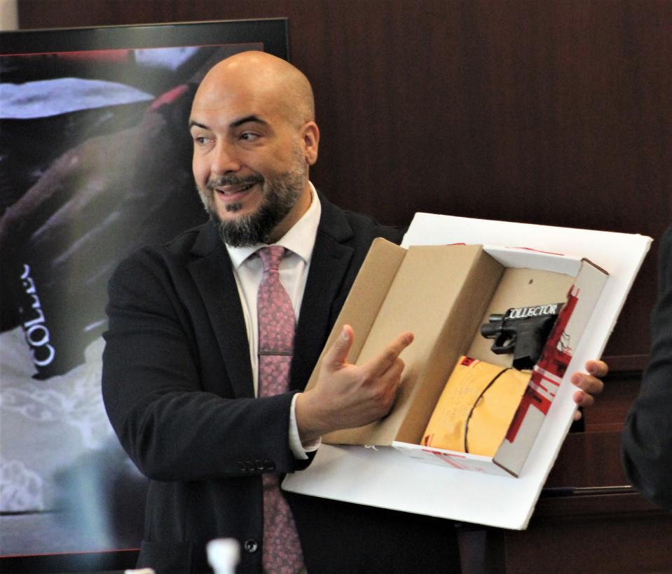 Flagler County Sheriff's Office Detective Agustin Rodriguez shows jurors Friday, April 12, 2024, a gun with the words "bone collector" written on it.