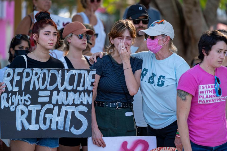 Erica Esch cries next to Ellen Baker, right, and Faith Halstead, left, during a protest after the Supreme Court overturned Roe v. Wade in West Palm Beach, Florida on June 24, 2022. Many women across the nation are concerned about the impact of the decision on their mental and physical well being.