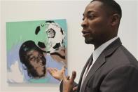 Curator Franklin Sirmans stands next to "Pele" by Andy Warhol during construction of the exhibition, "Futbol: The Beautiful Game", at the Los Angeles County Museum of Art (LACMA) in Los Angeles, California, January 27, 2014. REUTERS/David McNew