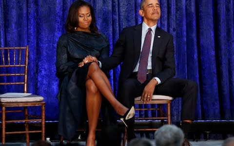Former President Obama and first lady Michelle Obama hold hands prior to portraits unveiling at the Smithsonian's National Portrait Gallery in Washington - Credit: Reuters