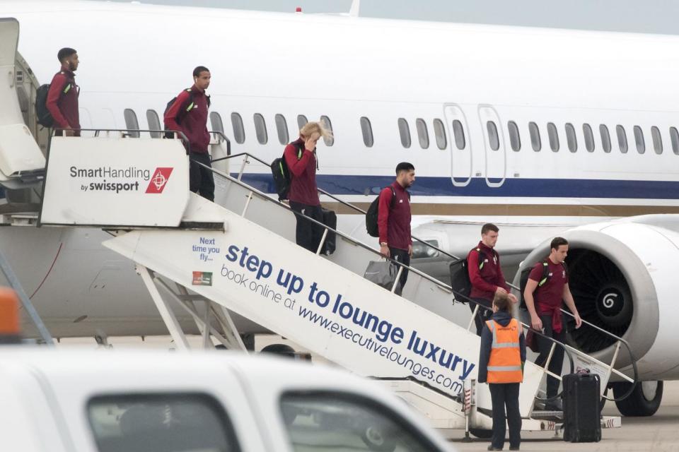 Liverpool players including Loris Karius, pictured with his hand over his face, get off their plane home at Liverpool's John Lennon airport Photo: PA