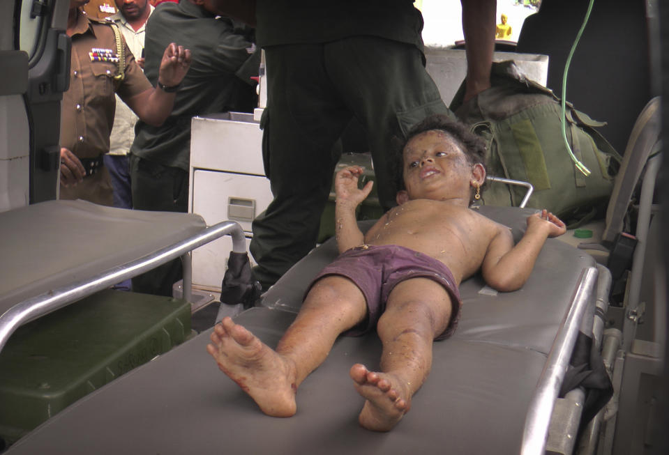 A Sri Lankan girl is taken to a hospital after she was found at the site of an explosion and a gunbattle in Kalmunai, eastern Sri Lanka, Saturday, April 27, 2019. Militants linked to Easter suicide bombings opened fire and set off explosives during a raid by Sri Lankan security forces on a house in the country's east. (AP Photo/Achala Upendra)