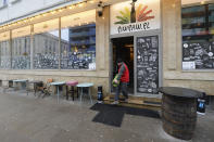 A man delivers a supply of heating gas to Warsaw's popular Piw Paw pub in Warsaw, Poland, Monday, Jan. 25, 2021, a business that is struggling to survive under lockdown by organizing legal, small-scale educative meetings and courses for beer lovers. (AP Photo/Czarek Sokolowski)