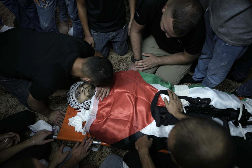 Mourners surround the Palestiian flag-draped body of Muhammad Alawneh, killed during an Israeli military raid in the occupied West Bank town of Jenin, Wednesday, Sept. 28, 2022. At least four Palestinians were killed and dozens of others wounded, the Palestinian Health Ministry reported, the latest in a series of deadly Israeli operations in the occupied territory. (AP Photo/ Majdi Mohammed)