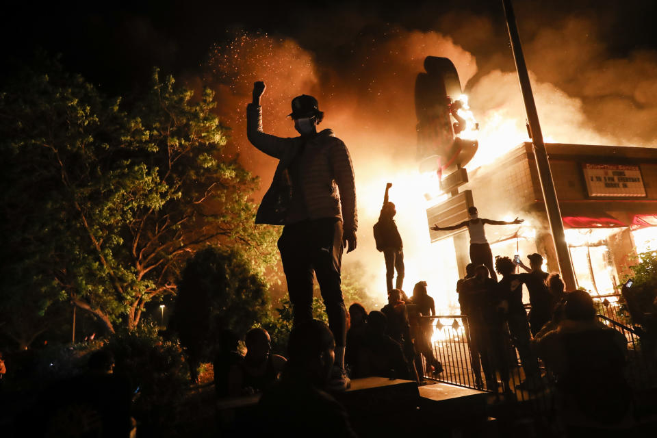 Protesters gather in front of a burning fast food restaurant, May 29, 2020, in Minneapolis. Protests over the death of George Floyd, a black man who died in police custody, broke out in Minneapolis for a third straight night. The image was part of a series of photographs by The Associated Press that won the 2021 Pulitzer Prize for breaking news photography. (AP Photo/John Minchillo)