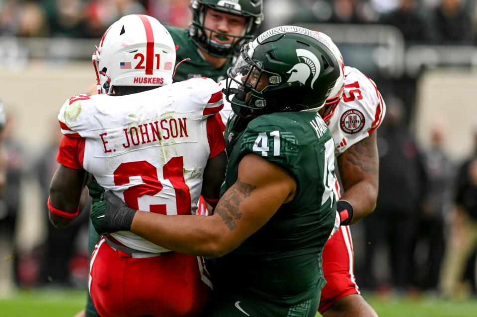 Michigan State's Derrick Harmon, right, tackles Nebraska's Emmett Johnson during the second quarter on Saturday, Nov. 4, 2023, at Spartan Stadium in East Lansing.