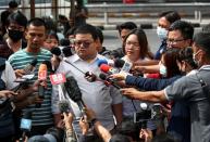 Protest leaders arrive to report themselves at a police station in Bangkok