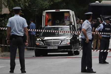 Police secure the area around the car of former Greek prime minister and former central bank chief Lucas Papademos following the detonation of an envelope injuring him and his driver, in Athens, Greece, May 25, 2017. REUTERS/Costas Baltas