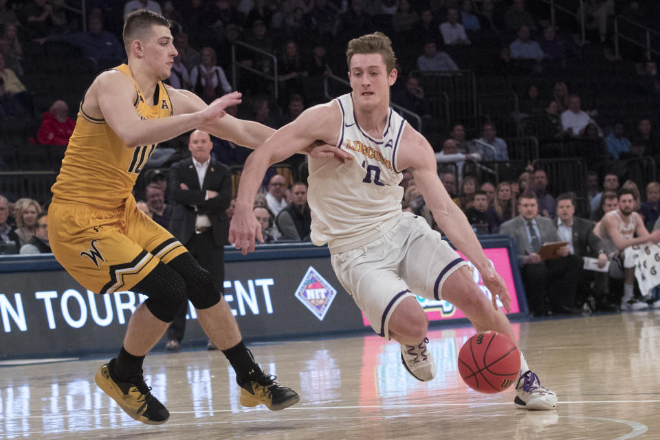 Lipscomb guard Jake Wolfe, right, drives to the basket against Wichita State guard Erik Stevenson during the first half of a semifinal college basketball game in the National Invitational Tournament, Tuesday, April 2, 2019, at Madison Square Garden in New York. (AP Photo/Mary Altaffer)