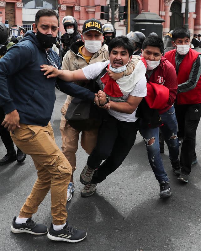 Plainclothes officers detain a man during protests after Peru's interim President Manuel Merino was sworn in following the removal of President Martin Vizcarra, in Lima