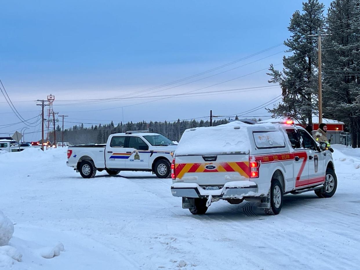 Emergency vehicles with flashing lights wait outside the Fort Smith airport Tuesday morning. (Carla Ulrich/CBC - image credit)