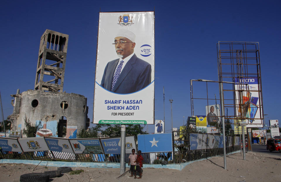 Somali children walk past a billboard showing presidential candidate Sharif Hassan Sheikh Aden in Mogadishu, Somalia Thursday, Jan. 28, 2021. As Somalia marks three decades since a dictator fell and chaos engulfed the country, the government is set to hold a troubled national election but two regional states are refusing to take part in the vote to elect Somalia's president and time is running out before the Feb. 8 date on which mandates expire. (AP Photo/Farah Abdi Warsameh)