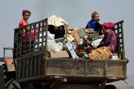 People ride on a truck with their belongings in Deraa countryside, Syria June 22, 2018. REUTERS/Alaa al-Faqir