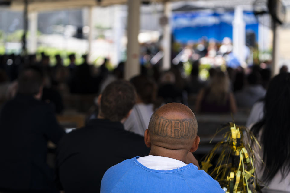A prisoner with tattoos on his head listens to a speech during a graduation ceremony at Folsom State Prison in Folsom, Calif., Thursday, May 25, 2023. (AP Photo/Jae C. Hong)