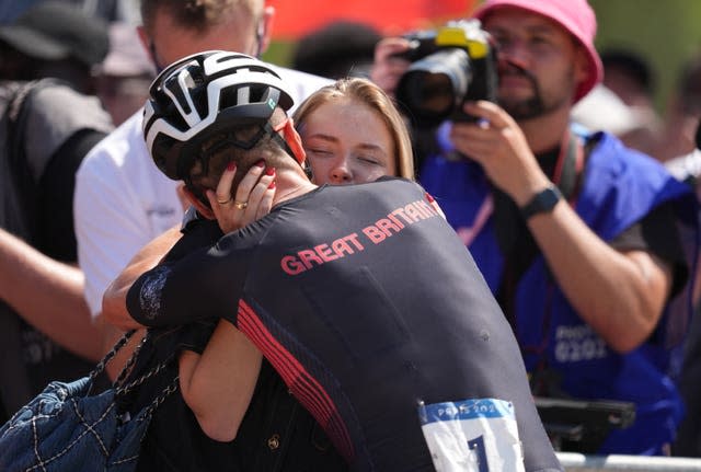 Tom Pidcock hugs his family after winning gold. 