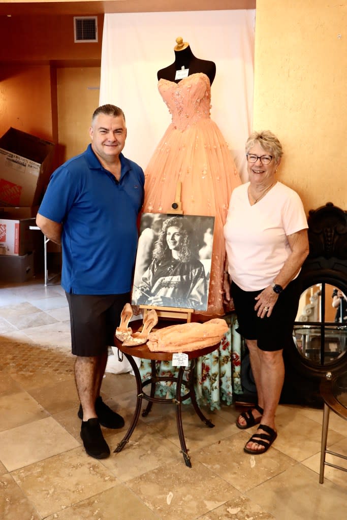 A pair of fans pose with items found at the bustling sale. mom&paparazzi/MEGA for NY Post