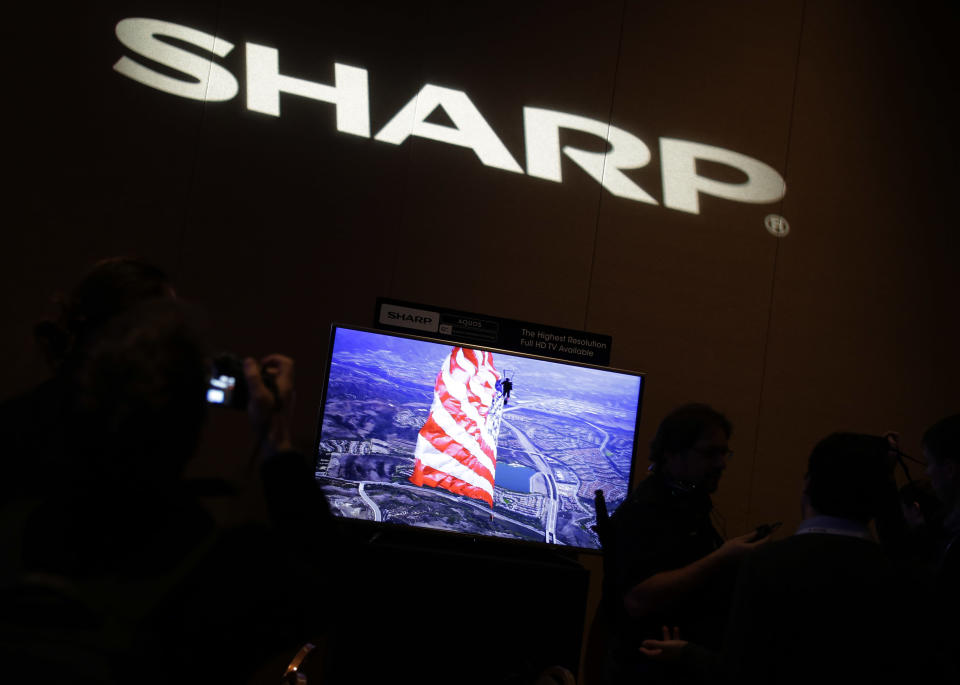Journalists check out the new Sharp 4K lite television during a news conference at the Consumer Electronics Show press day on Monday, Jan. 6, 2014, in Las Vegas. (AP Photo/Isaac Brekken)