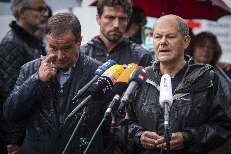 FILE - In this Tuesday, Aug.3, 2021 file photo Armin Laschet, top canditate of the German Christian Democrats for the federal elections, and Olaf Scholz, top canditate of the German Social Democrats, address the media during a press conference in Stolberg, Germany that was hit by heavy rain and floods. Climate change is among the top concerns for Germans going into this year's national election that will determine who replaces Angela Merkel as Chancellor. But while voters admit they are worried about the state of the planet, especially after last the deadly floods that hit Germany in July, many fear the cost of backing the environmentalist Green party that's campaigned strongest for meeting the Paris climate accord's goals. (Marius Becker/DPA via AP, Pool, file)