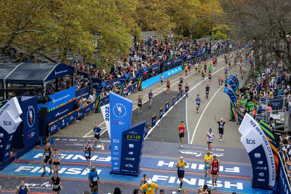 Runners cross the finish line in Central Park during the New York City Marathon on Nov. 6, 2022.