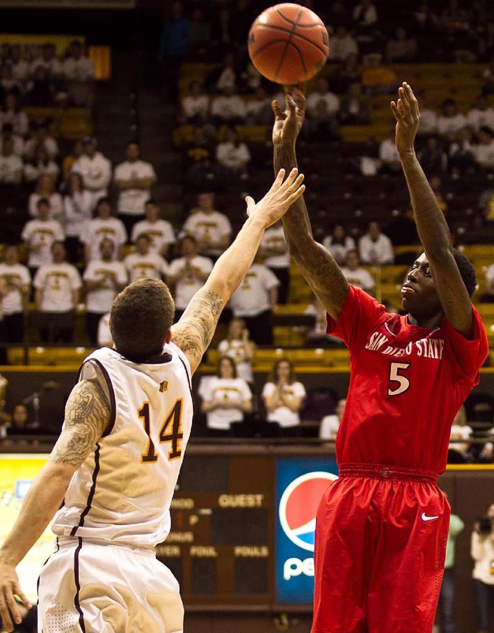 San Diego State forward Dwayne Polee II (5) pulls up for a jump shot over University of Wyoming Cowboy Josh Adams Tuesday, Feb. 11, 2014 at the Arena-Auditorium in Laramie, Wyo. (AP Photo/Jeremy Martin)