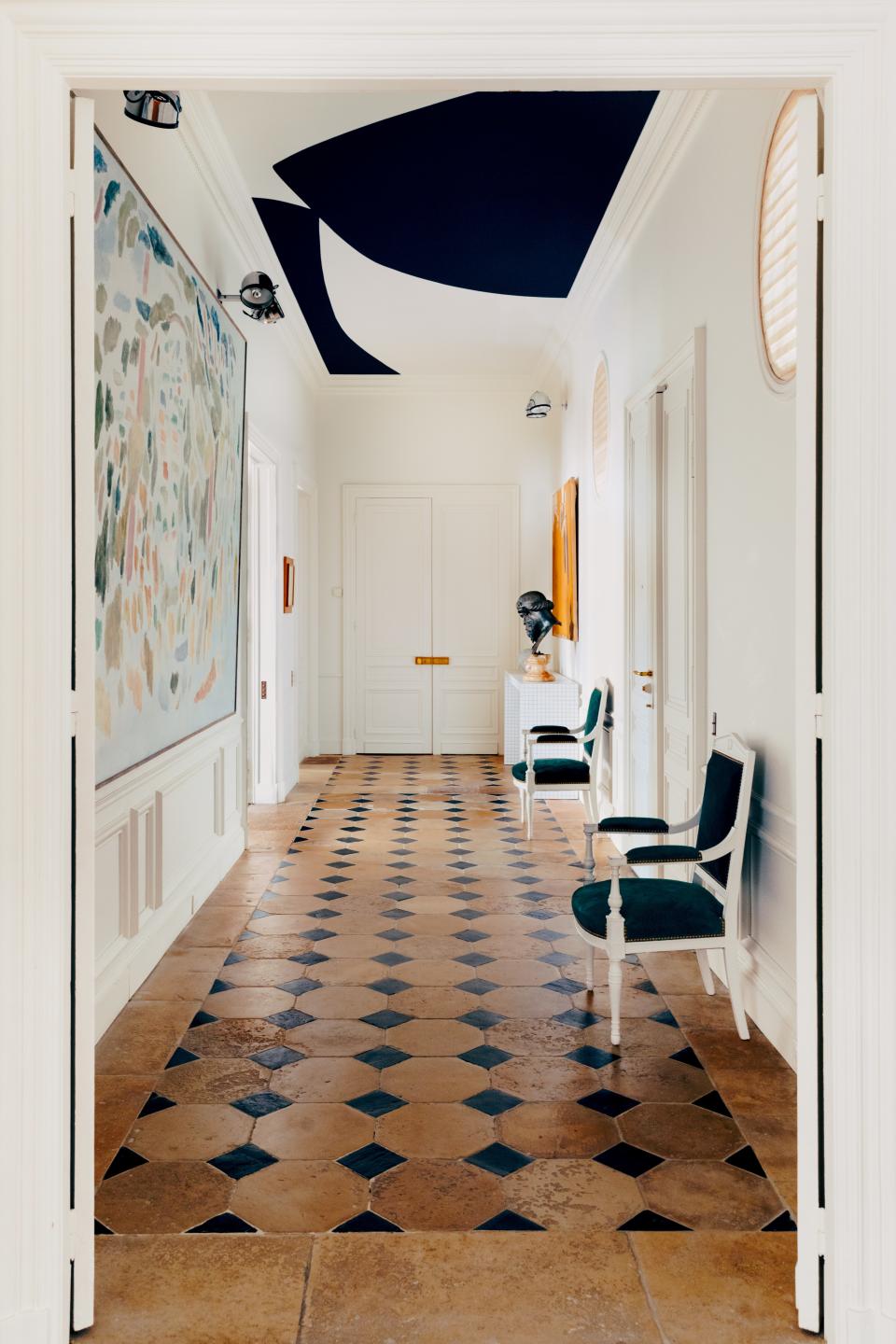 Casiraghi devised an abstract Ellsworth Kelly-inspired artwork for the ceiling of the entry hall. The 19th-century French armchairs wear a Nobilis fabric. 20th-century painting (left).