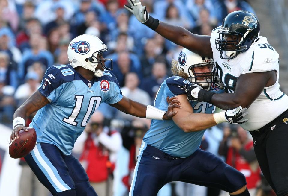 Vince Young (10), quarterback -- Young (10) scrambles away from Jacksonville Jaguars defensive tackle John Henderson (98) as he is protected by guard Jake Scott (73)  in the first quarter of their game at LP Field November 1, 2009