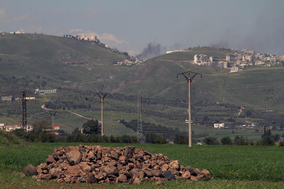 Black smoke billows from the village of Hosn, center, as seen during a government-led tour for reporters on the Crac des Chevaliers, a white building on a hilltop left of the smoke, a day after Syrian troops ousted rebels from the castle in Syria, Friday, March 21, 2014. The Syrian army ousted rebels from a massive Crusader fortress after several hours of fierce fighting, killing at least 93 of them as they fled to neighboring Lebanon, an army commander told reporters on a government-led tour of the area Friday. (AP Photo)