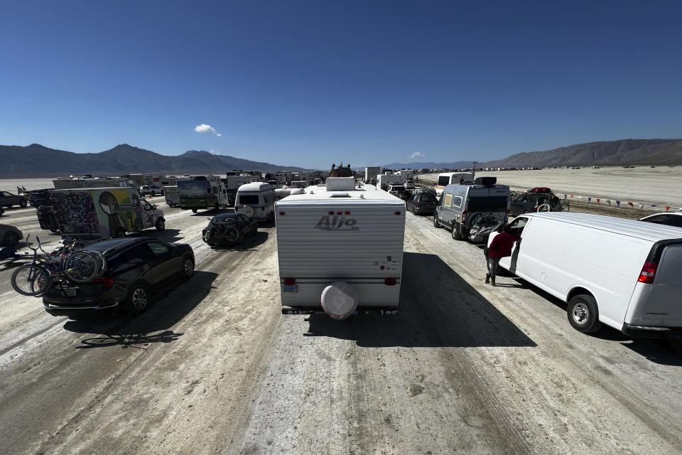 Vehicles line up to leave the Burning Man festival in Black Rock Desert, Nev., Tuesday, Sept. 5, 2023. The traffic jam leaving the festival eased up considerably Tuesday as the exodus from the mud-caked Nevada desert entered a second day following massive rain that left tens of thousands of partygoers stranded there for days.(Monique Sady via AP)