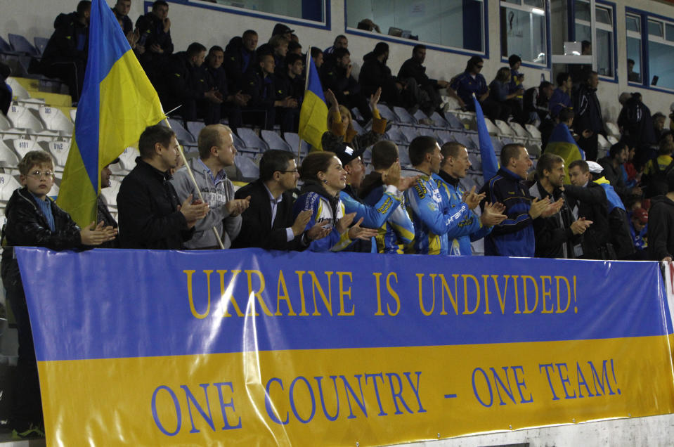 Ukrainians with a banner reading "Ukraine is Undivided!" cheer their national soccer team during an international friendly match between Ukraine and U.S. at Antonis Papadopoulos stadium in southern city of Larnaca, Cyprus, Wednesday, March 5, 2014. The Ukrainians are to face the United States in a friendly on Wednesday in Cyprus, a match moved from Kharkiv to Larnaca for security reasons. (AP Photo/Petros Karadjias)