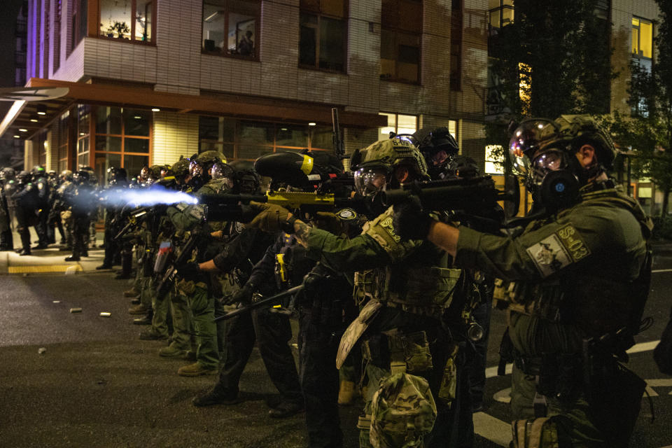 Federal police try to take control of the streets during protests, Friday, Sept. 18, 2020, in Portland, Ore. The protests, which began over the killing of George Floyd, often result frequent clashes between protesters and law enforcement. (AP Photo/Paula Bronstein)