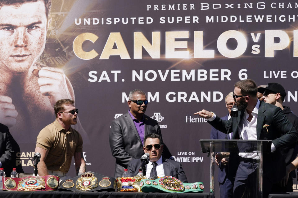 Unified WBC/WBO/WBA super middleweight champion Canelo Alvarez, left, has words with undefeated IBF Super Middleweight Champion Caleb Plant, second from right, after the scuffled during a news conference Tuesday, Sept. 21, 2021, in Beverly Hills, Calif. to announce their 168-pound title bout. The fight is scheduled for Saturday, Nov. 6 in Las Vegas. (AP Photo/Mark J. Terrill)