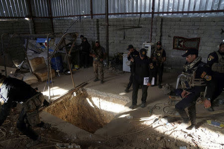 Iraqi security forces stand around a tunnel used by Islamic State militants at Bartila in the east of Mosul during an attack on Islamic State militants in Mosul. REUTERS/Stringer