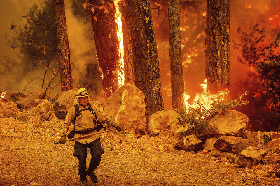 A firefighter walks a path as the Glass Fire burns along Highway 29 in Calistoga, Calif., on Thursday, Oct. 1, 2020. (AP Photo/Noah Berger)