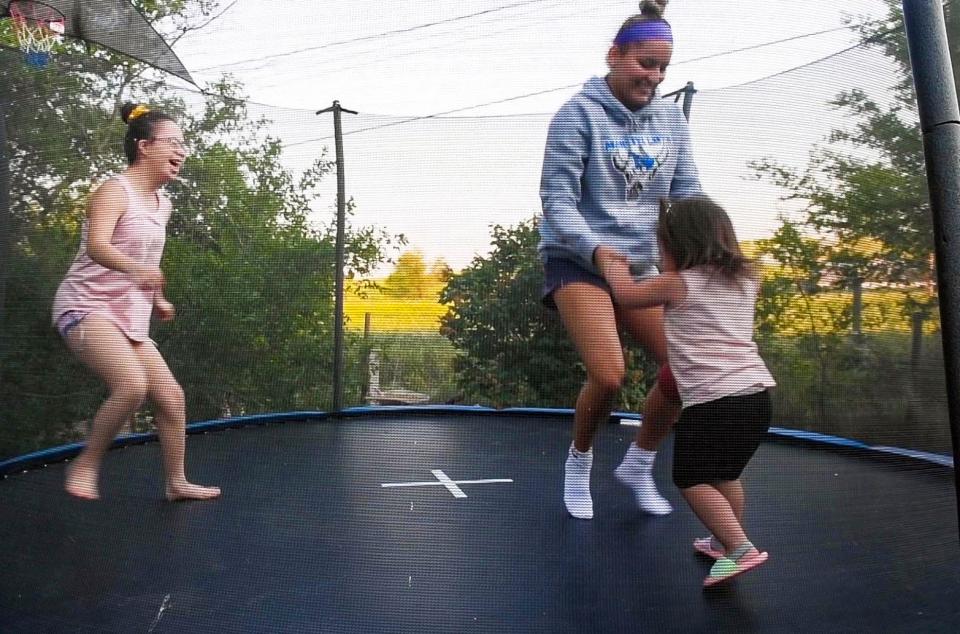 Stevi Fallis, center, bounces on a trampoline with her younger sisters, Stephanie and Amari, on  June 16 on the Pine Ridge Reservation.