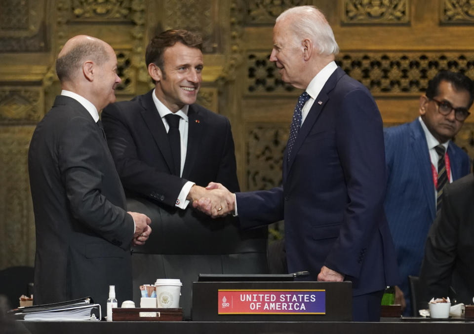 U.S. President Joe Biden, French President Emmanuel Macron and German Chancellor Olaf Scholz greet each other during the first working session of the G20 leaders' summit in Nusa Dua, Indonesia, Tuesday, Nov. 15, 2022. (Kevin Lamarque/Pool via AP)