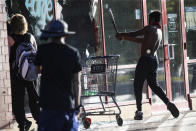 FILE - In this May 28, 2020 file photo, a protestor breaks a window of a business with a baseball bat, in St. Paul, Minn. The destruction caused by vandals and looters in cities across the country, who struck as demonstrators took to the streets in reaction to the killing of George Floyd in Minneapolis, has devastated small businesses already reeling from the coronavirus outbreak. (AP Photo/John Minchillo, File)